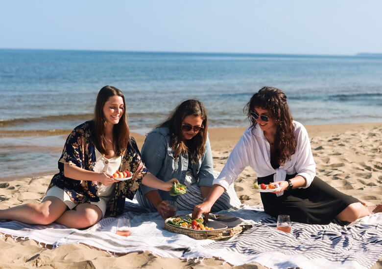 three women picnicking on beach