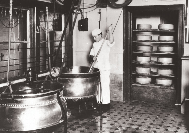 male cheesemaker in room with vats